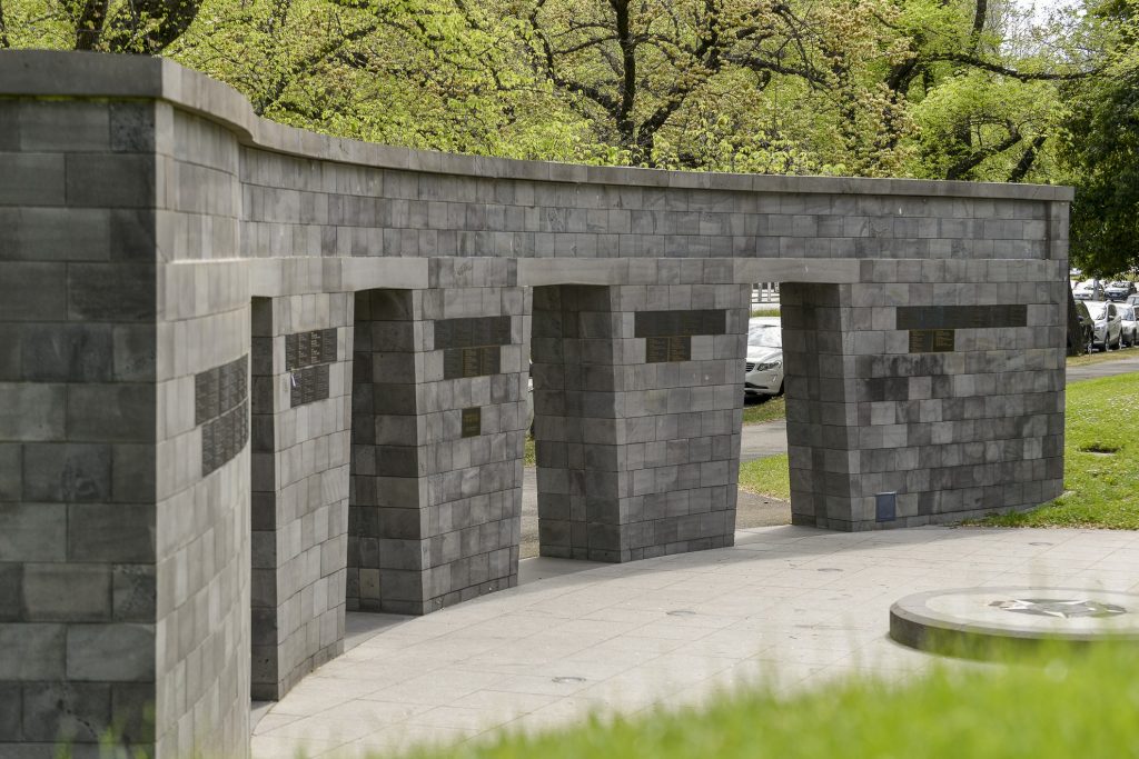 Curving stone memorial wall set among trees, Victoria Police Memorial in Melbourne.